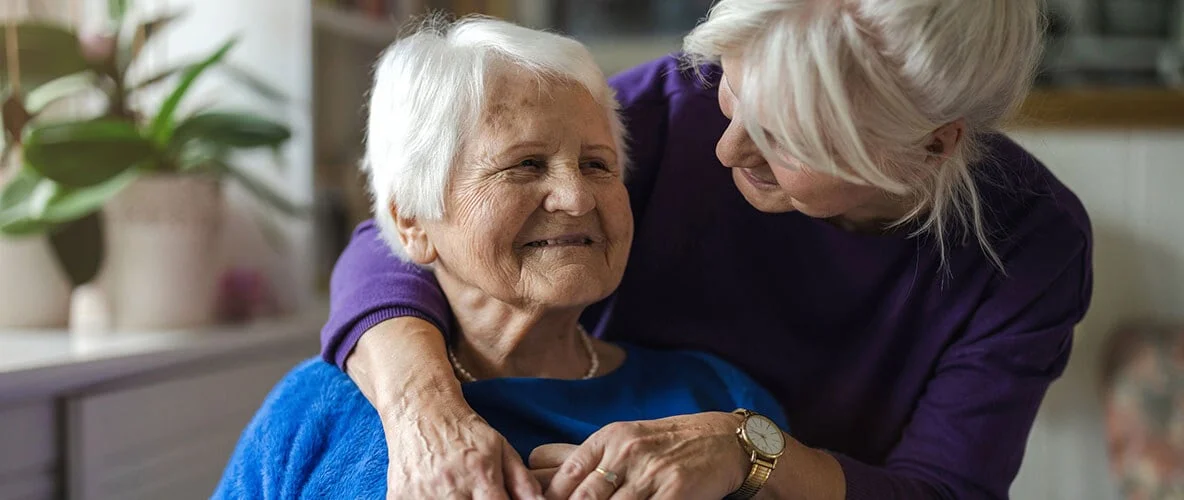 A loved one hugging a senior woman