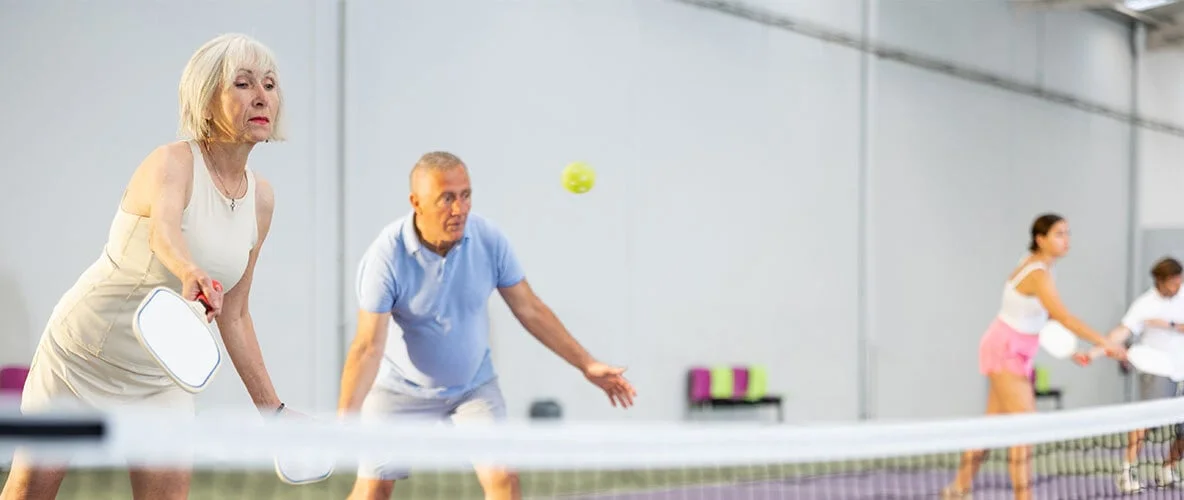 Senior residents participating in a friendly group sports activity indoors