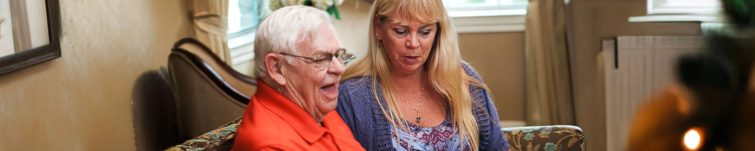 Senior resident receiving support from caregiver in assisted living community