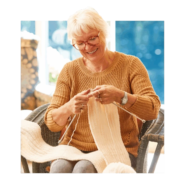 Senior sitting down knitting