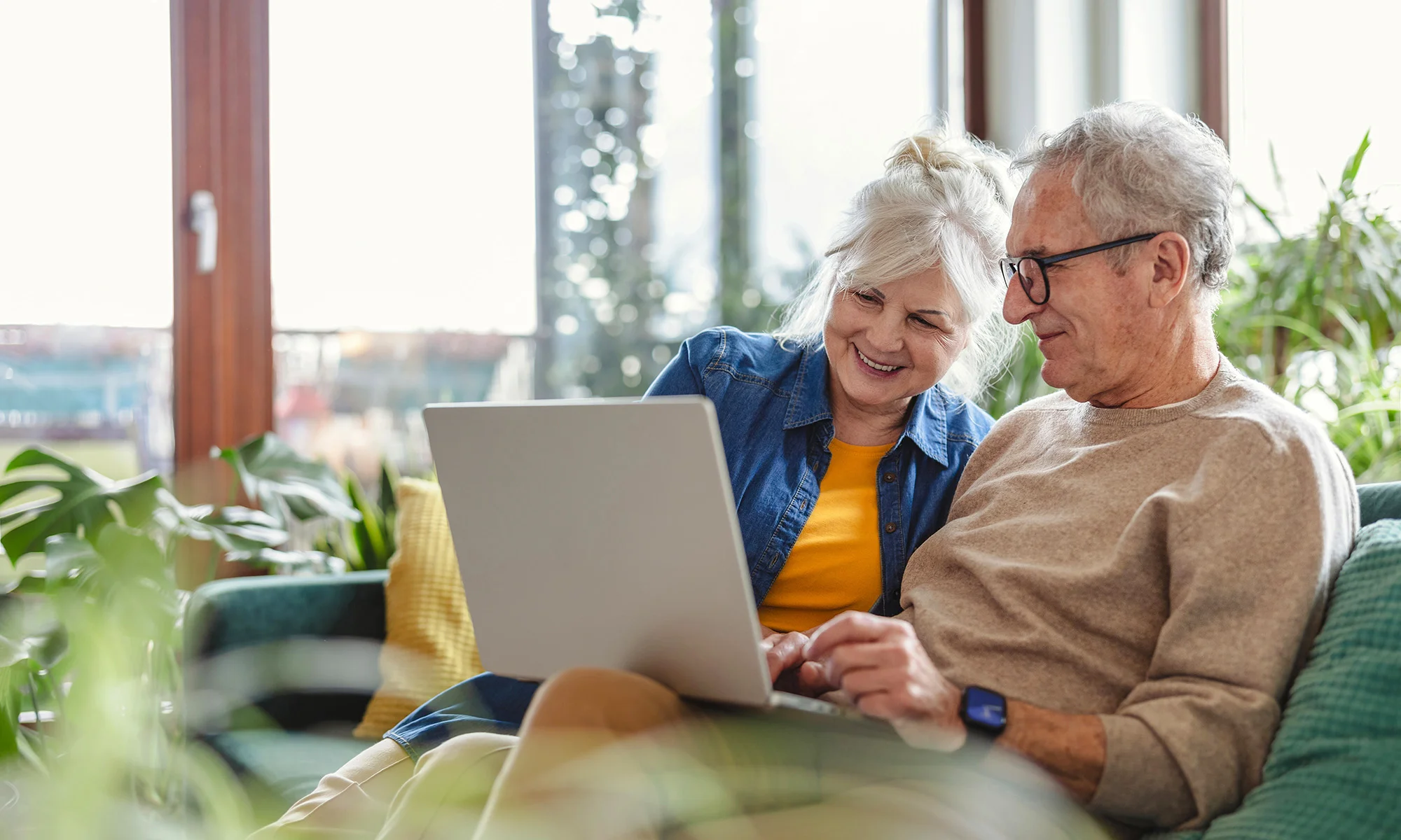 Senior couple using laptop to check senior living options.