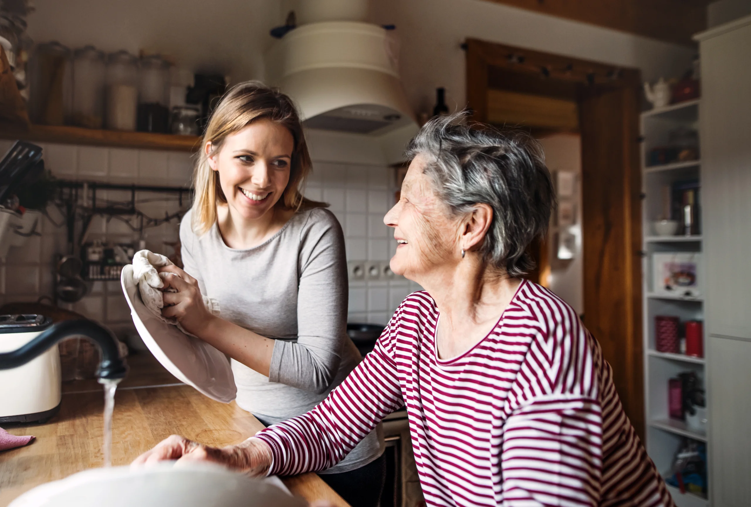 A young woman having a conversation with a much older woman about memory care.